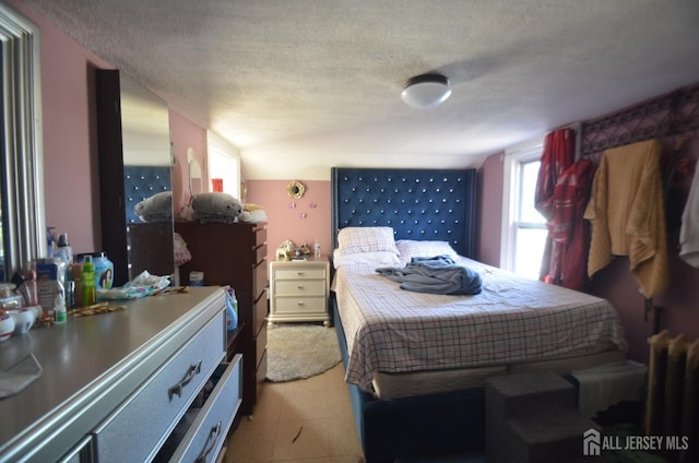 bedroom with radiator heating unit and a textured ceiling