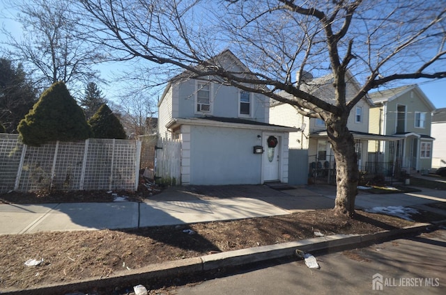 view of side of property with stucco siding and fence