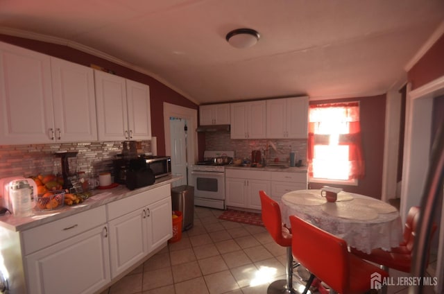 kitchen featuring white cabinetry, lofted ceiling, light tile patterned floors, and white range oven