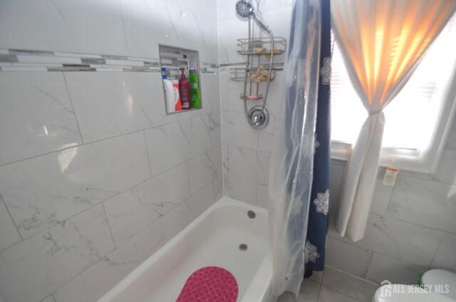 bathroom with shower / tub combo with curtain and toilet