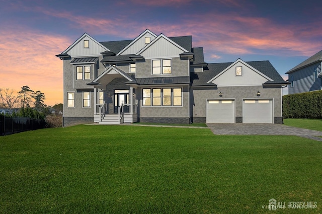 modern inspired farmhouse featuring a lawn, metal roof, an attached garage, a standing seam roof, and decorative driveway