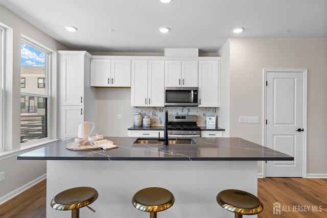 1306 Parker Blvd, West Windsor, NJ 08550 - kitchen featuring appliances with stainless steel finishes, a kitchen breakfast bar, white cabinetry, dark countertops, and recessed lighting