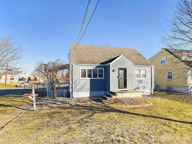 bungalow featuring a front lawn and a shingled roof