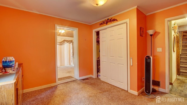 carpeted entrance foyer with crown molding