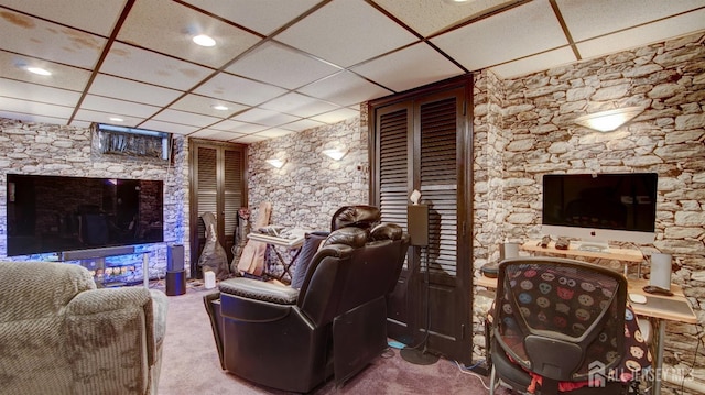 carpeted home theater room with a drop ceiling