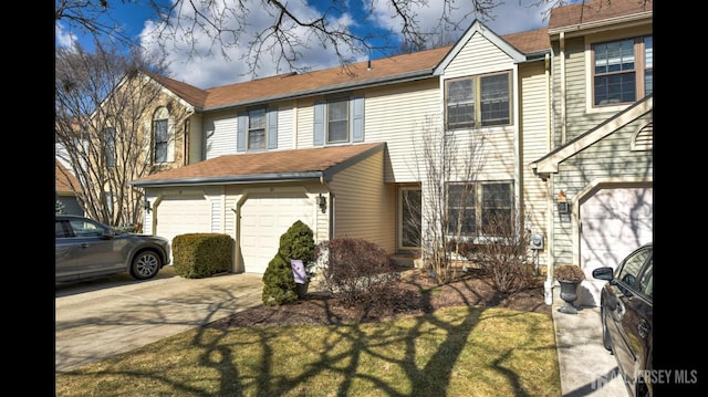 multi unit property featuring a garage and driveway