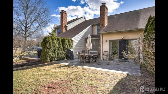 rear view of house with a yard and a patio