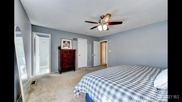 bedroom with arched walkways, visible vents, a textured ceiling, and carpet