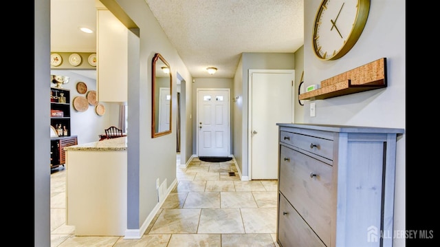 hallway with baseboards and a textured ceiling