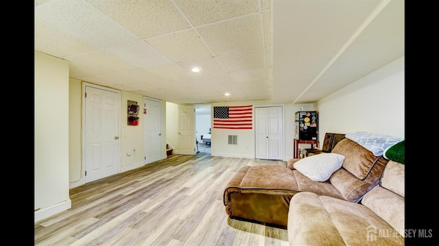 living area with visible vents, baseboards, stairs, and light wood finished floors