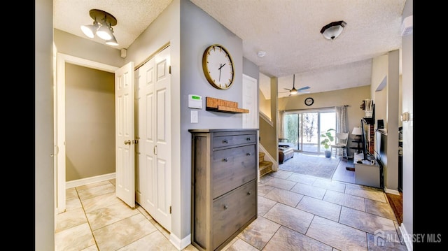 corridor with baseboards and a textured ceiling