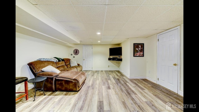 living area with recessed lighting, a drop ceiling, baseboards, and wood finished floors