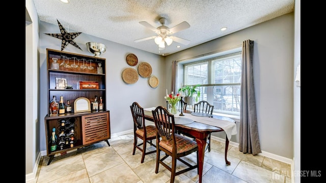 dining area with a dry bar, baseboards, and a textured ceiling