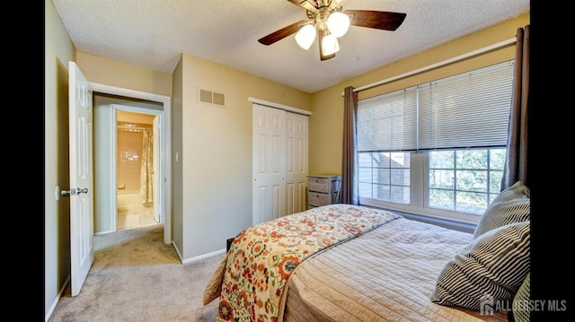 bedroom featuring light colored carpet, visible vents, a closet, and a textured ceiling