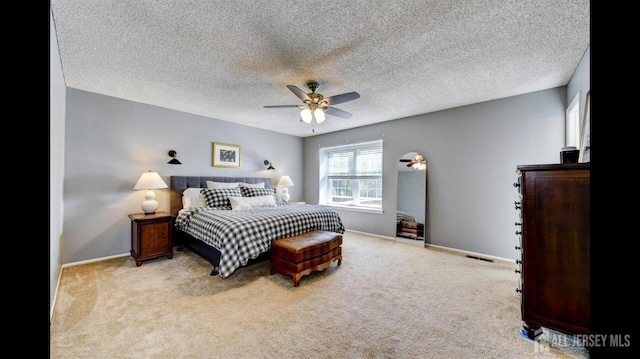 carpeted bedroom featuring a ceiling fan, baseboards, visible vents, and a textured ceiling