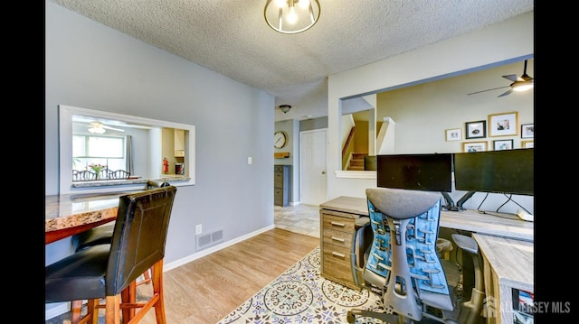 office area with ceiling fan, visible vents, a textured ceiling, and wood finished floors