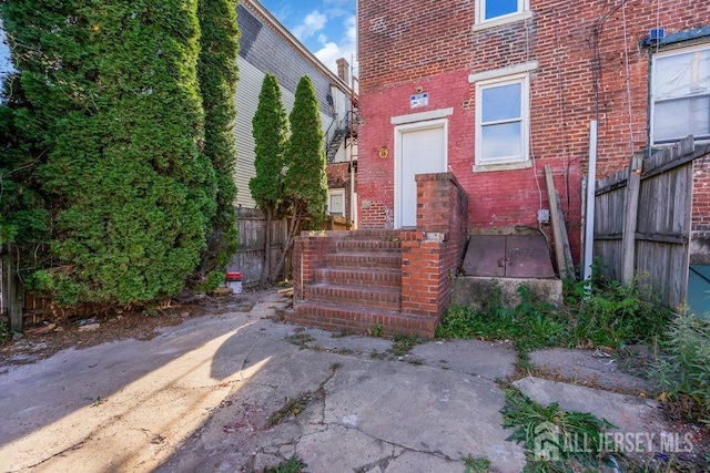 entrance to property with fence and brick siding