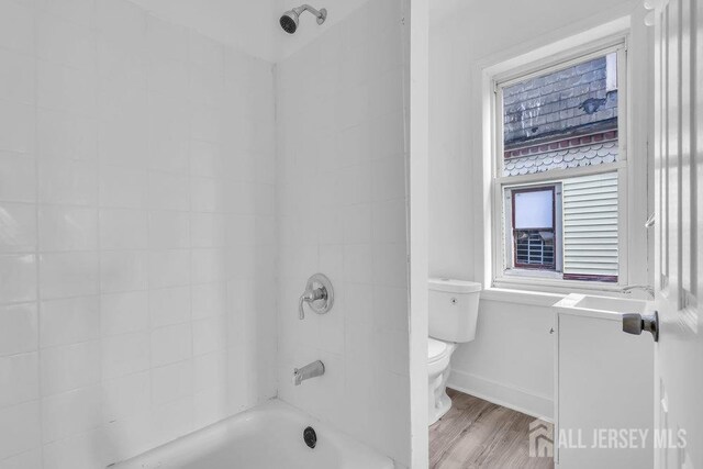 full bathroom featuring shower / washtub combination, toilet, hardwood / wood-style floors, and vanity