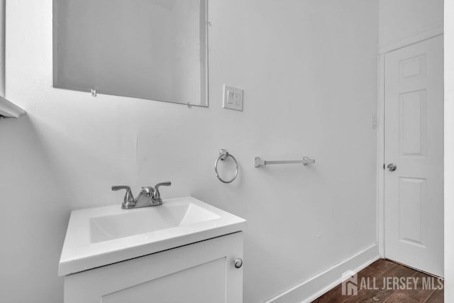 bathroom featuring vanity, baseboards, and wood finished floors