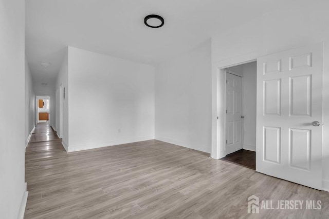 unfurnished room with baseboards and wood finished floors