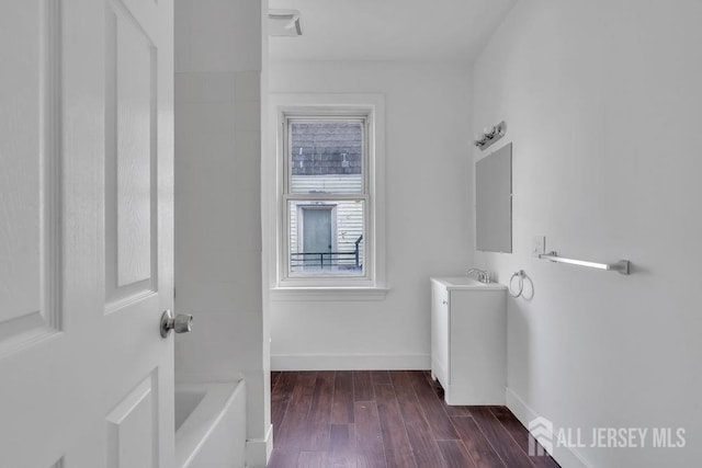 bathroom with vanity, hardwood / wood-style floors, and a bath