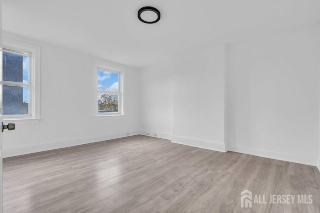 unfurnished room with baseboards and wood finished floors