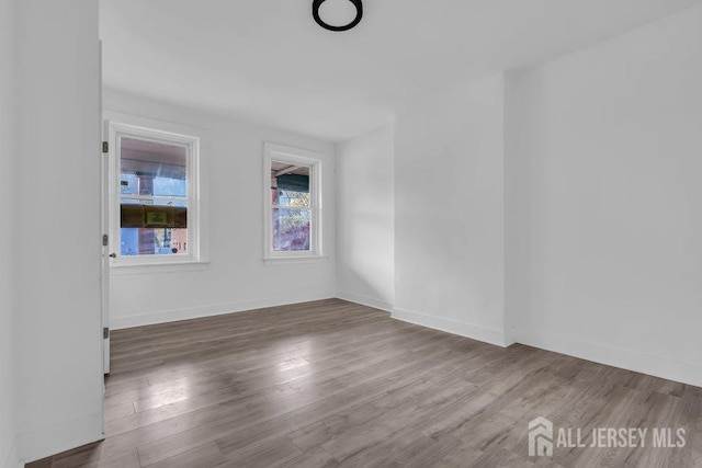 spare room with wood finished floors and baseboards