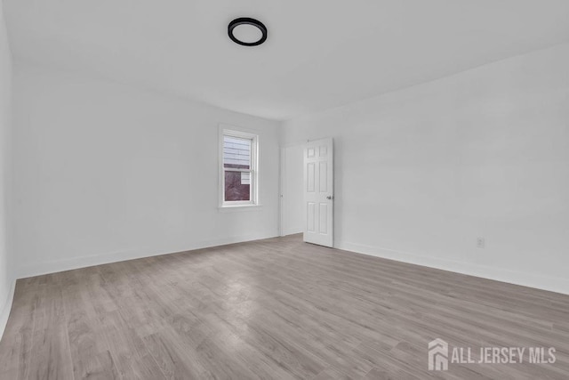 unfurnished room with wood finished floors and baseboards