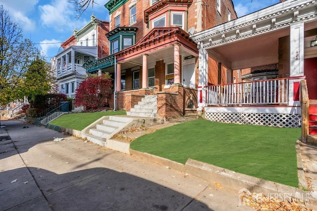 view of front of property with a porch and a front lawn