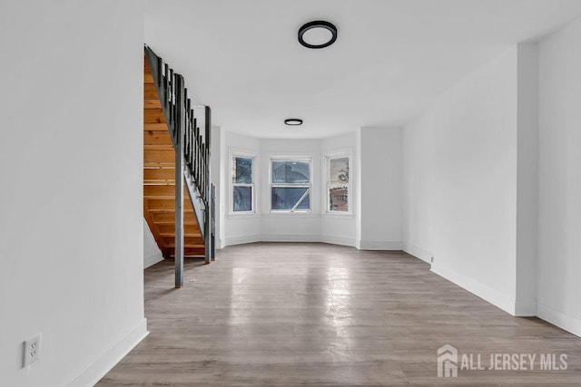 interior space featuring baseboards, wood finished floors, and stairs