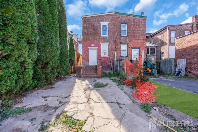 view of front of property featuring brick siding and fence