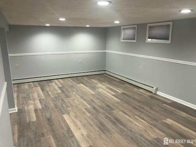 finished basement with recessed lighting, wood finished floors, baseboards, and baseboard heating