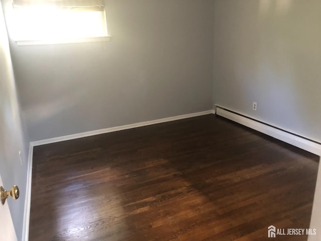 empty room featuring baseboards and dark wood-style flooring