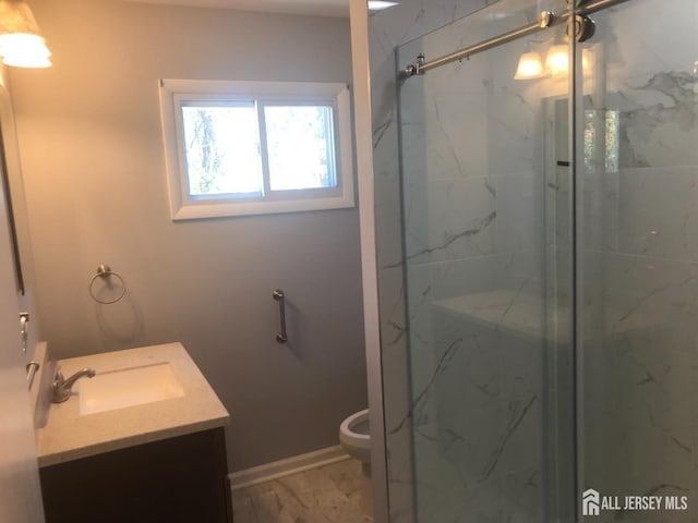 full bath with a marble finish shower, toilet, marble finish floor, and vanity