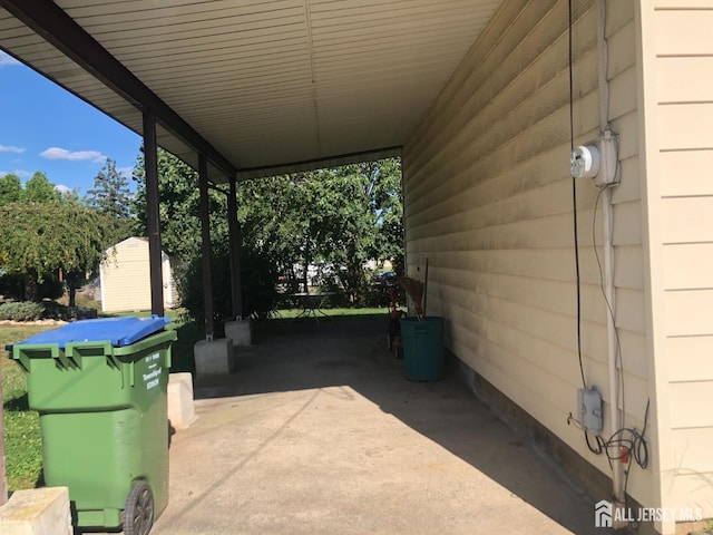 view of patio with a storage shed, an outbuilding, and a carport