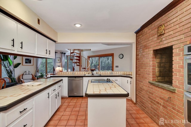 25 Deer Path, Holmdel, NJ 07733 - kitchen featuring brick wall, light tile patterned floors, a kitchen island, white cabinetry, and a peninsula