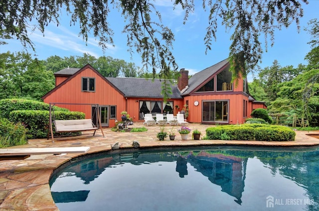 25 Deer Path, Holmdel, NJ 07733 - rear view of property with a patio, a chimney, an outdoor pool, and board and batten siding