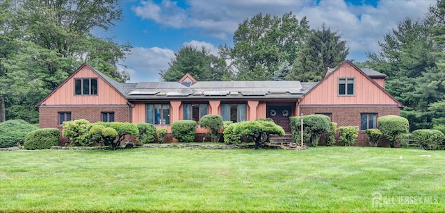 25 Deer Path, Holmdel, NJ 07733 - view of front facade with a front yard, brick siding, and roof mounted solar panels