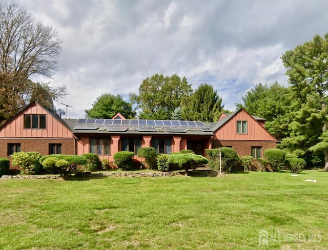 25 Deer Path, Holmdel, NJ 07733 - view of front of home featuring solar panels, a front yard, and brick siding