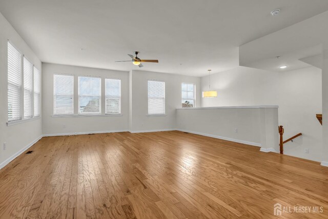 empty room with ceiling fan and light wood-type flooring