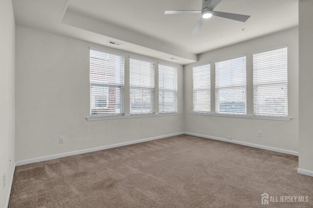 spare room with light colored carpet and ceiling fan