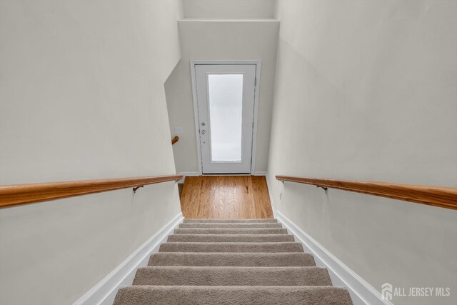 stairway with hardwood / wood-style floors