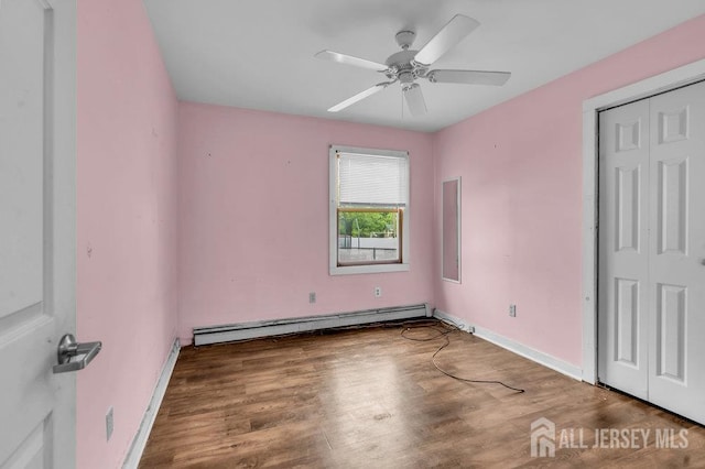 12 Dey St, Englishtown, NJ 07726 - unfurnished bedroom featuring a baseboard radiator, wood finished floors, a closet, and ceiling fan