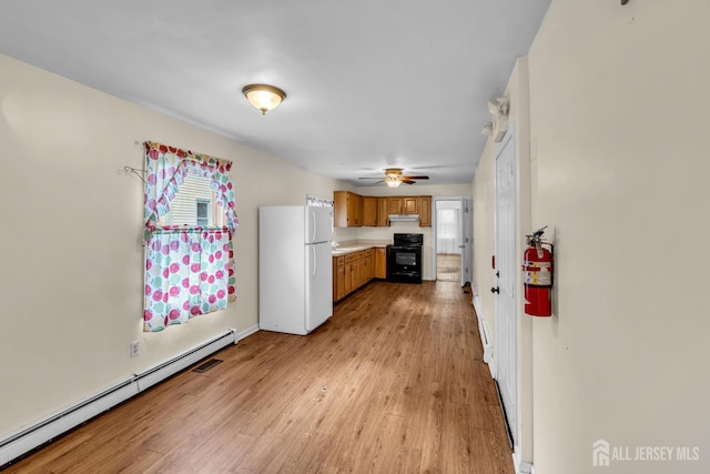12 Dey St, Englishtown, NJ 07726 - kitchen featuring freestanding refrigerator, a baseboard heating unit, range, brown cabinetry, and light wood-type flooring