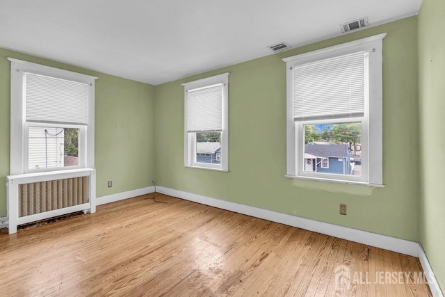 12 Dey St, Englishtown, NJ 07726 - spare room with radiator, wood finished floors, and plenty of natural light