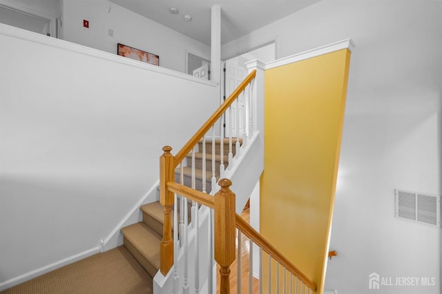 stairway with carpet, visible vents, and baseboards