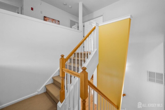 staircase with carpet flooring and visible vents