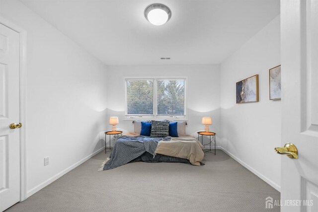carpeted bedroom featuring baseboards and visible vents