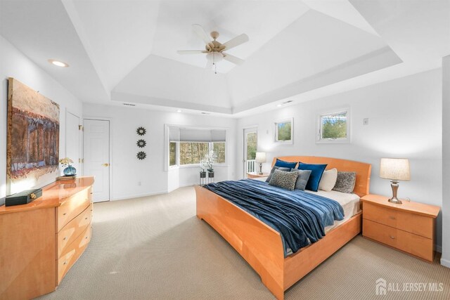 bedroom featuring ceiling fan, light carpet, recessed lighting, baseboards, and a tray ceiling
