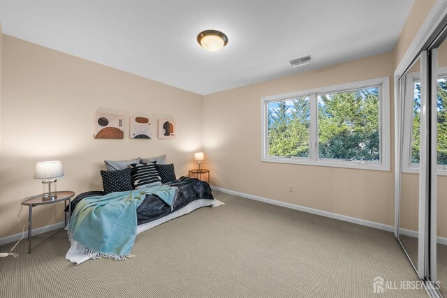 bedroom with baseboards, visible vents, and carpet